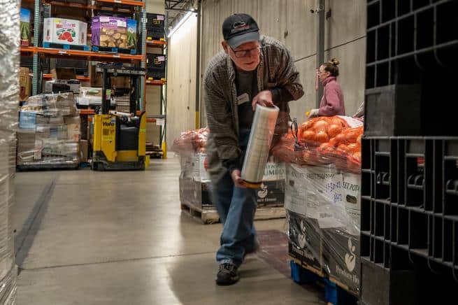 food bank volunteer wrapping a pallet.