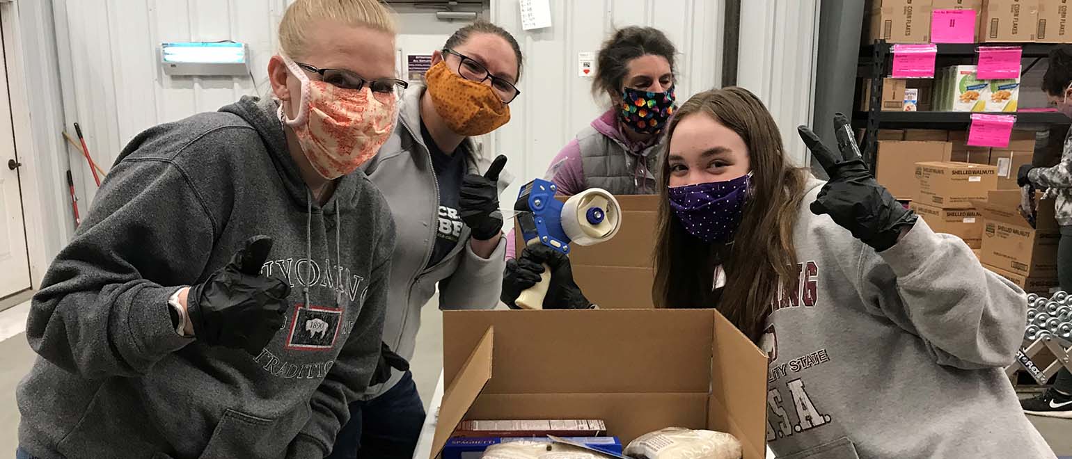 Volunteers in masks packing food