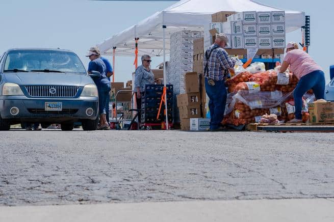 Volunteers loading food boxes into cars at distribution event