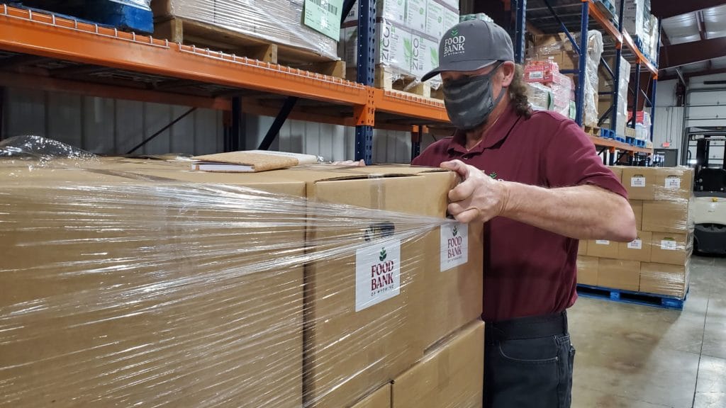 food bank employee wrapping a pallet of food