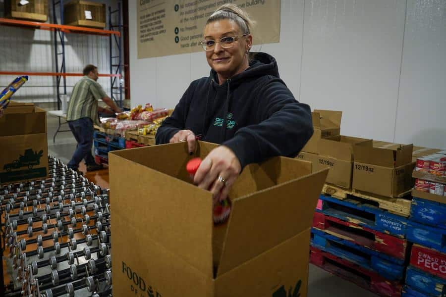 Woman packing food into a Food Bank of Wyoming box.