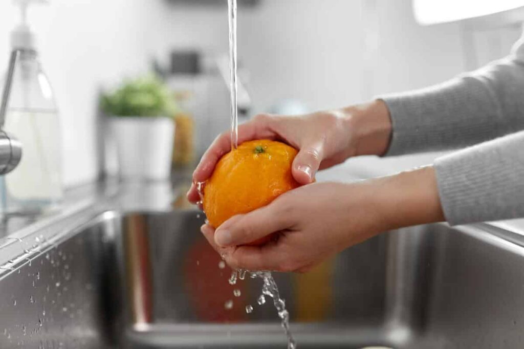 Orange being washed in water