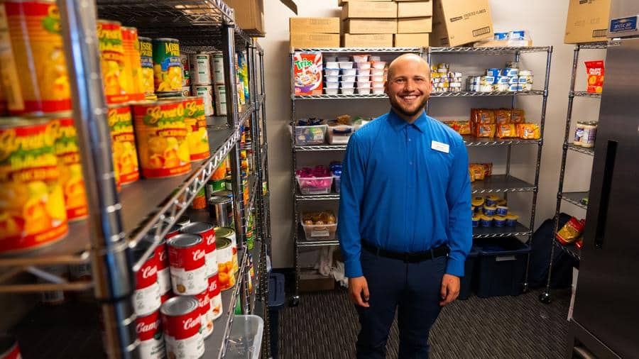 a person in a blue shirt standing inside of the Casper College food pantry