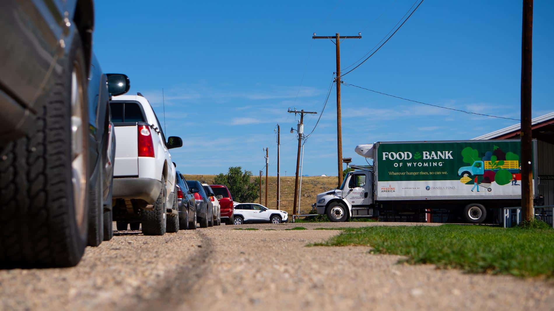 Line of cars and a Food Bank of Wyoming truck at a mobile pantry