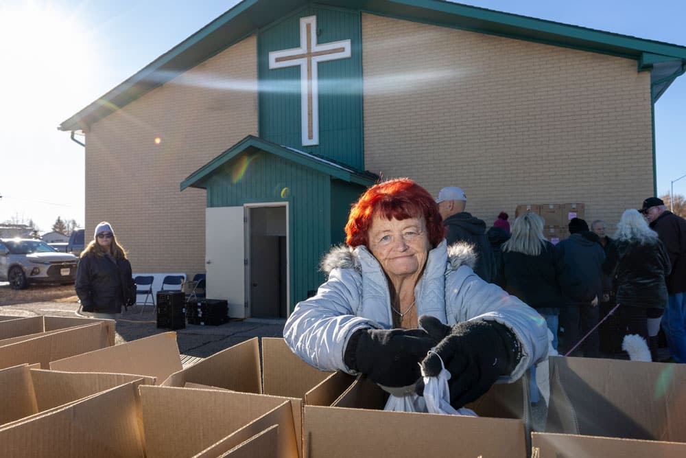 Volunteer packing a box in front of a church