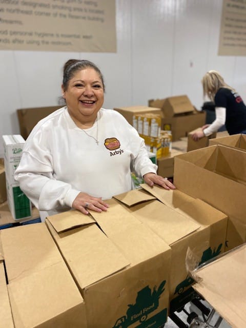 Woman volunteering wearing an Arby's shirt.