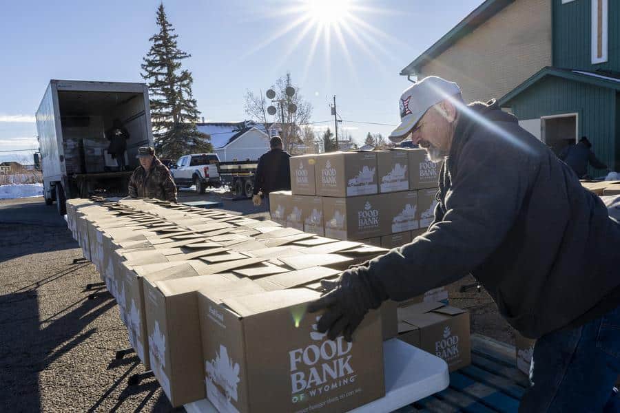 Man setting up Food Bank of Wyoming boxes on a table at a mobile pantry.