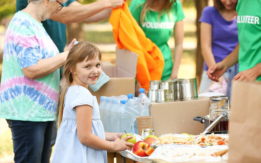 Young girl at a table with food.