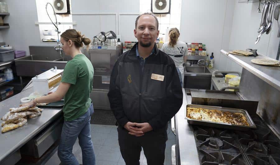 Man standing in commercial kitchen.