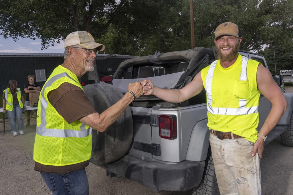 Volunteer fist bumping a visiting neighbor.