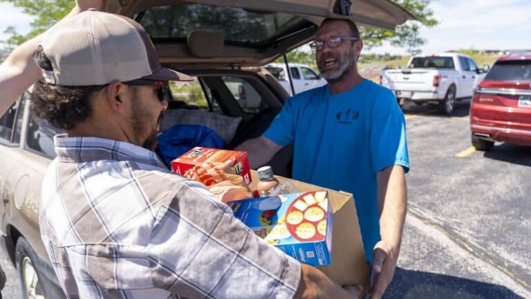 a man standing outside receiving a box of food