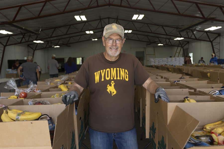 Man standing between rows of open boxes.