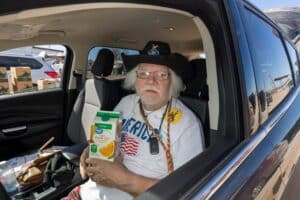 Dallas inside car holding carton of orange juice.