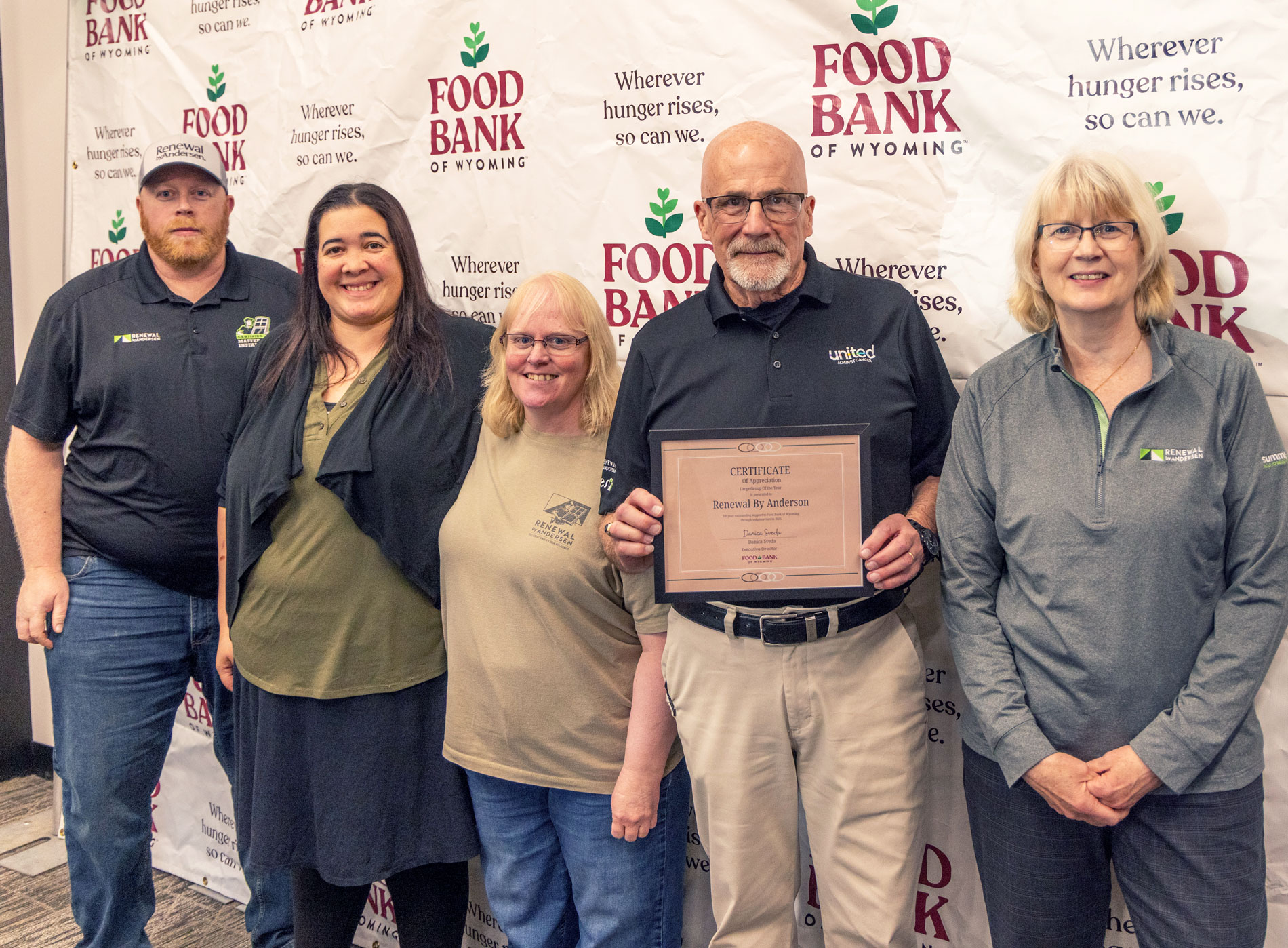 Group from Renewal by Andersen standing in front of Food Bank of WY backdrop.