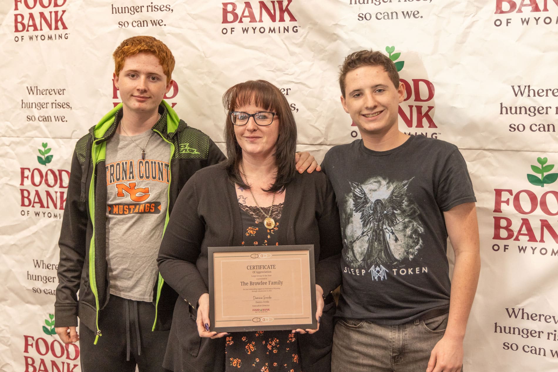 Browlee family standing in front of Food Bank of WY backdrop.