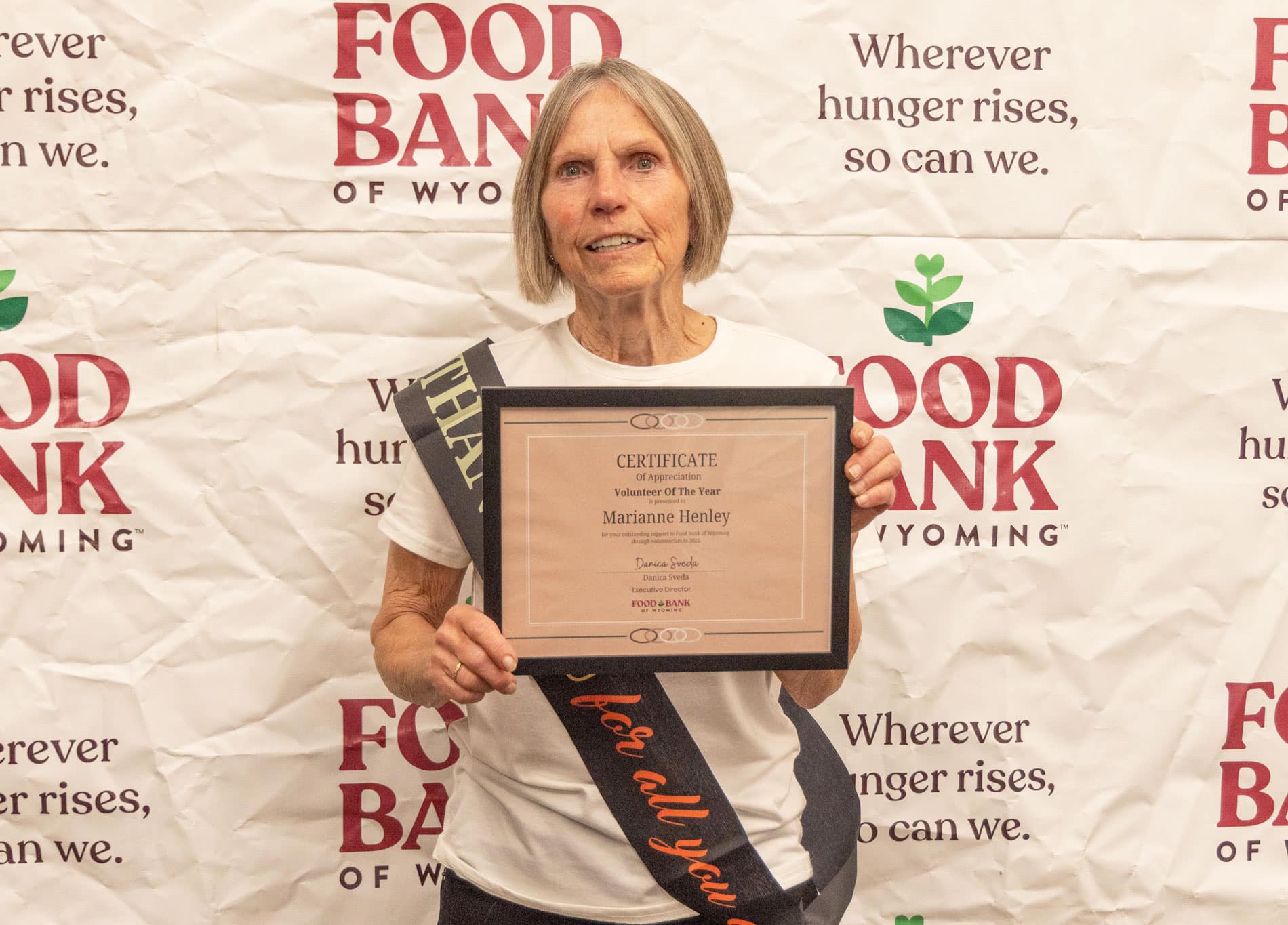 Marianne Henley standing in front of Food Bank of WY backdrop.