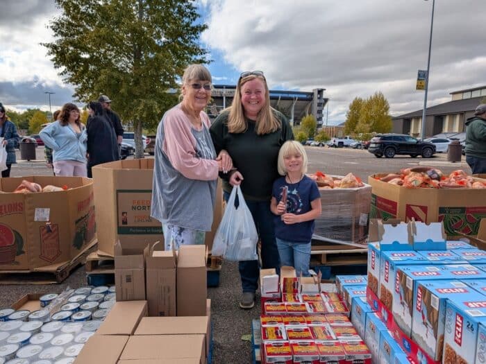 Mom, Grandmother, and Daugher at a pop up mobile pantry.