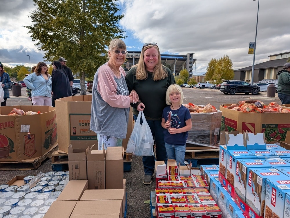 Mom, Grandmother, and Daugher at a pop up mobile pantry.
