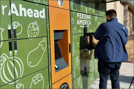 Booth of cooling lockers and a person collecting food out of one of the lockers.