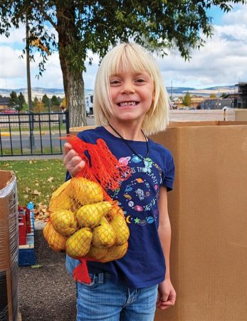a child holding a bag of pears